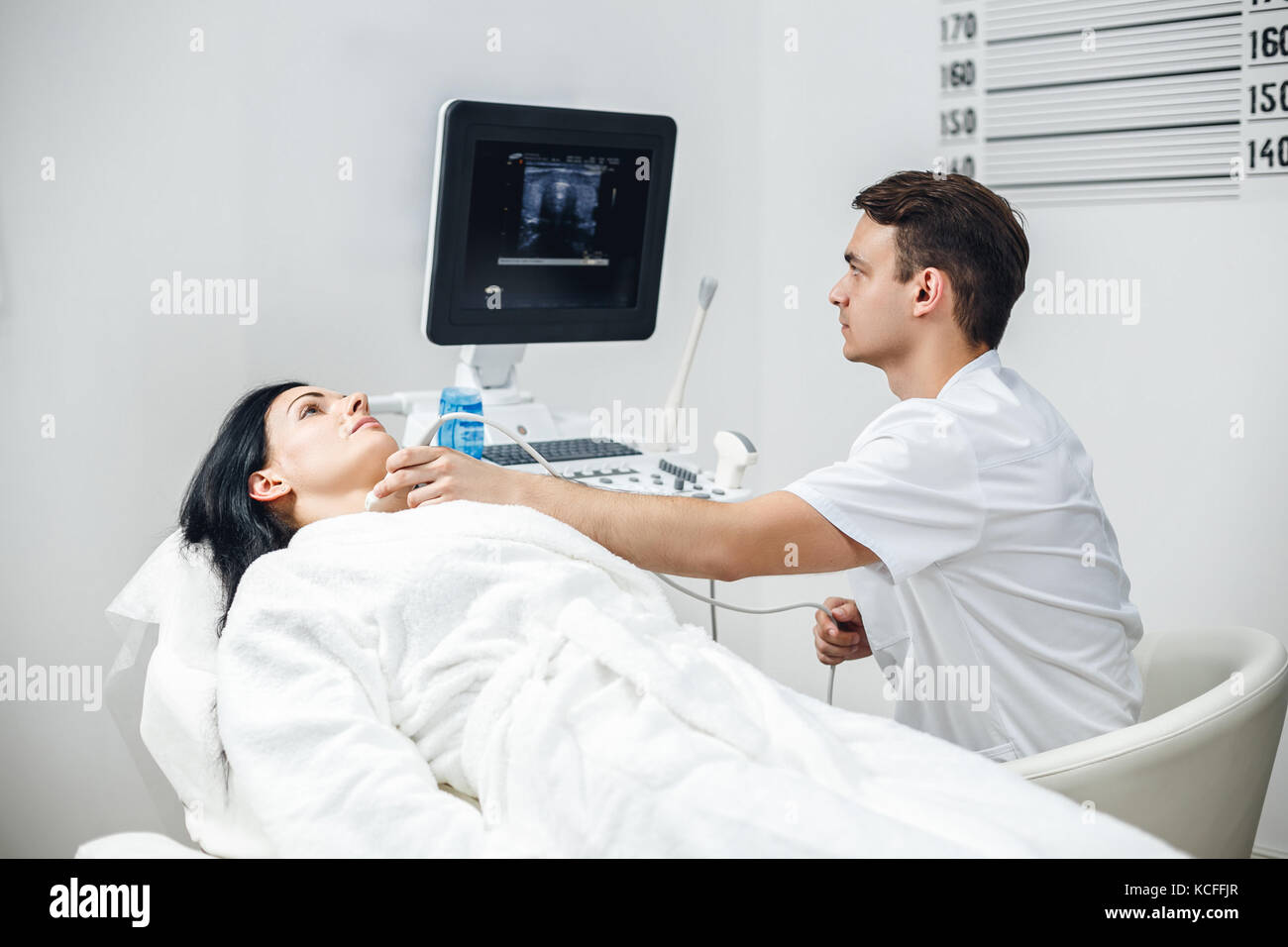 Fröhliche Frau Patient in der Schilddrüse Ultraschall checkup in der