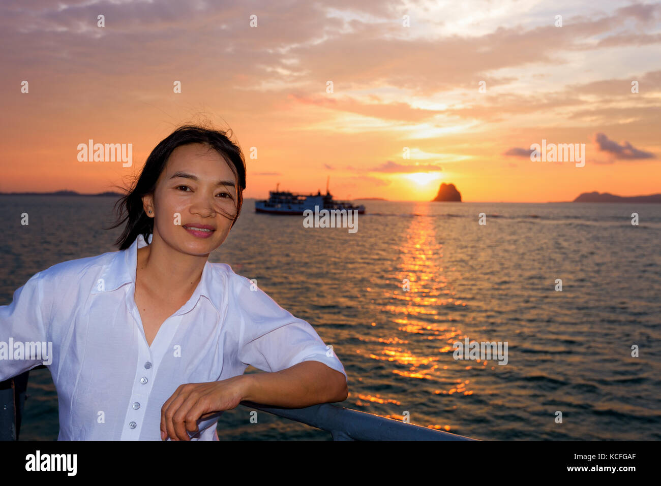 Wunderschöne Natur bunte Himmel und Sonne bei Sonnenuntergang über dem Meer, Frauen Touristen auf dem Deck eines großen Pkw Boot während der Fahrt nach Koh Samui Insel Stockfoto