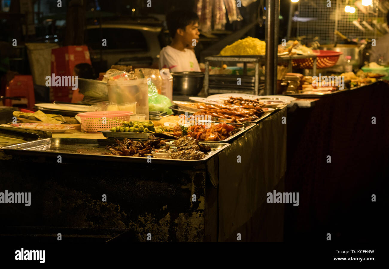 Ein asiatisches Essen Hersteller, Verkauf Straße essen im Phnom Penh Night Market, in Kambodscha. Das Essen ist meistens gebraten und billig, Experimentieren und serviert asiatische Küche. Stockfoto