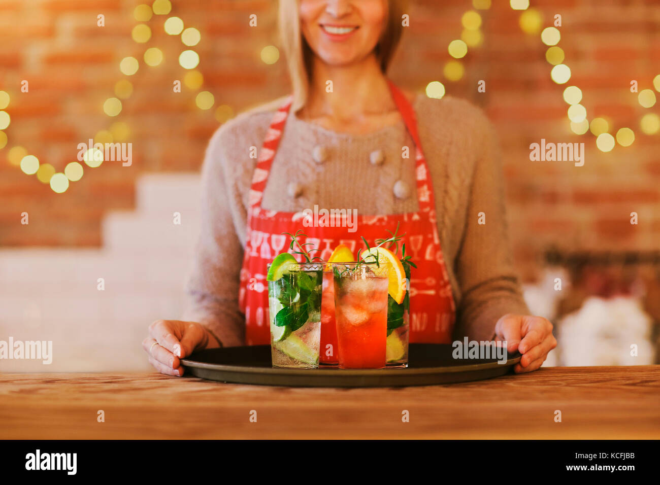 Junge hübsche Frau mit roten und grünen Cocktails auf Fach in der Bar Stockfoto