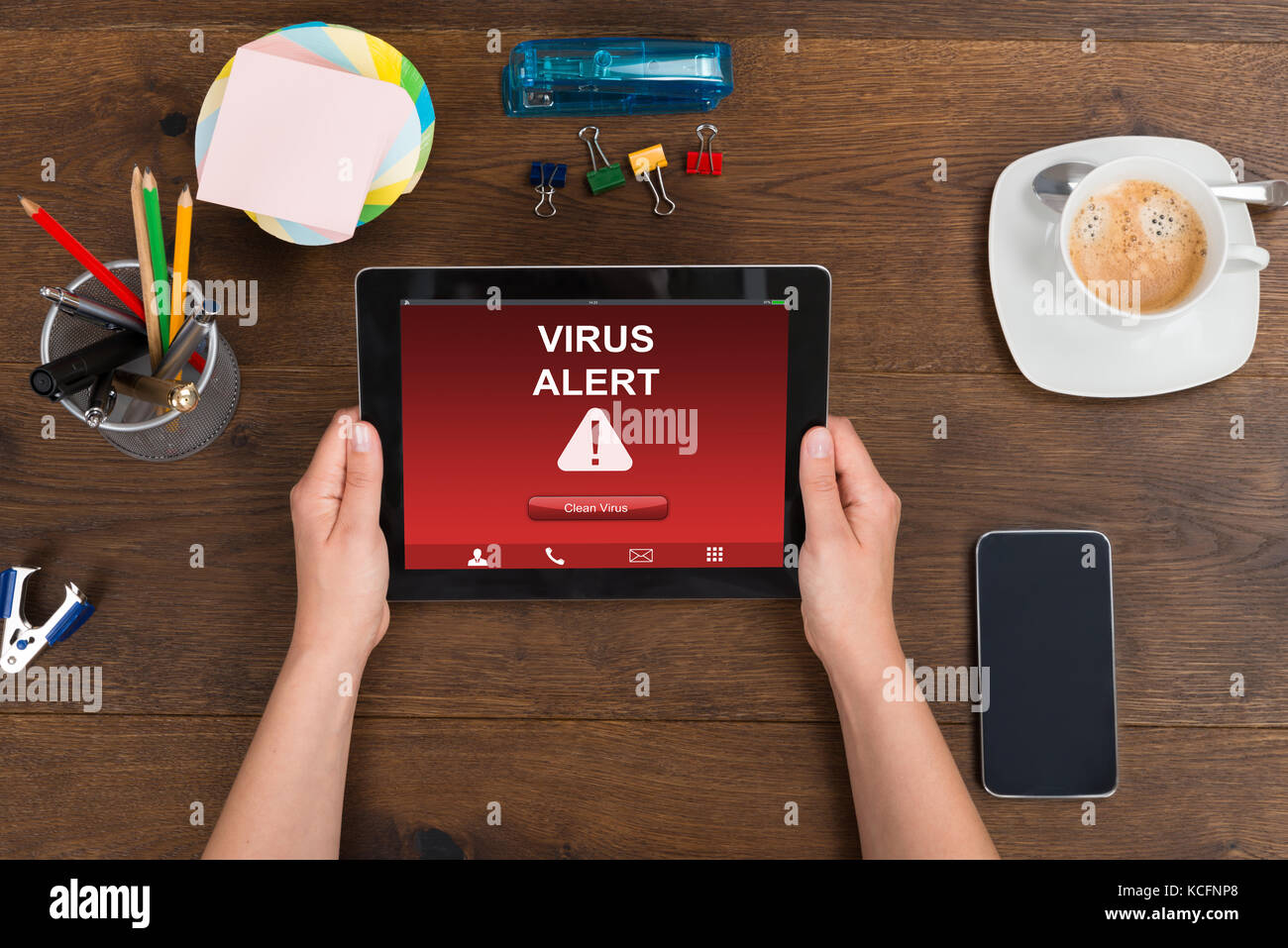 Hohe Betrachtungswinkel und der Person, die digitale Tablet mit Virus Warnung auf hölzernen Schreibtisch Stockfoto