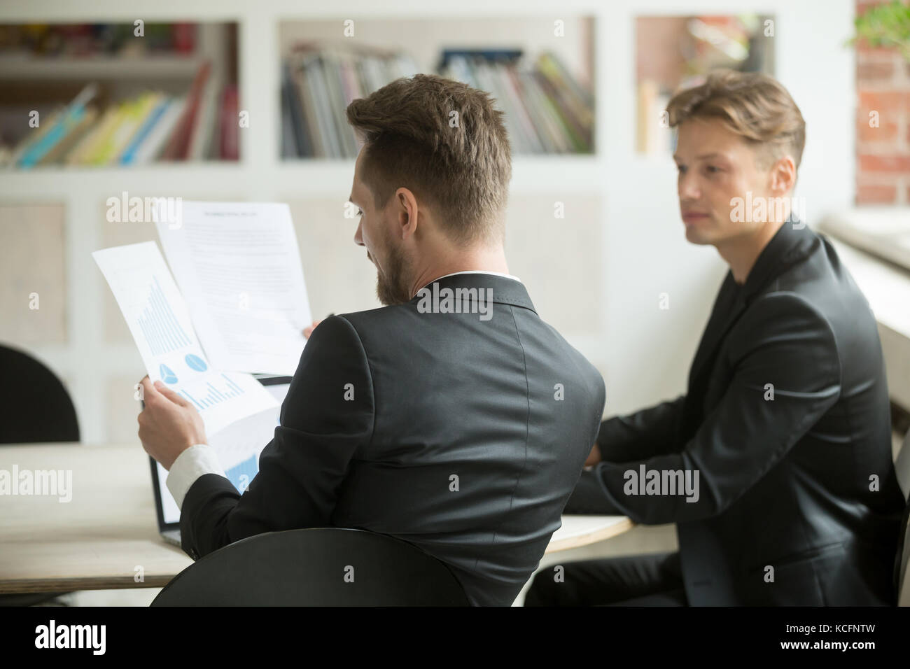 Zwei junge Unternehmer Mitarbeiter analysieren finanziellen Notfall Bericht am Schreibtisch in modernen Büro. Project Manager und ceo die Überwachung der Fortschritte. Stockfoto