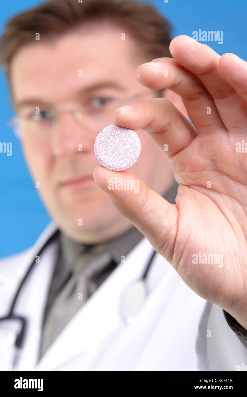 Arzt Holding rosa Tablette mit seinen zwei Fingern bis sein Gesicht Stockfoto