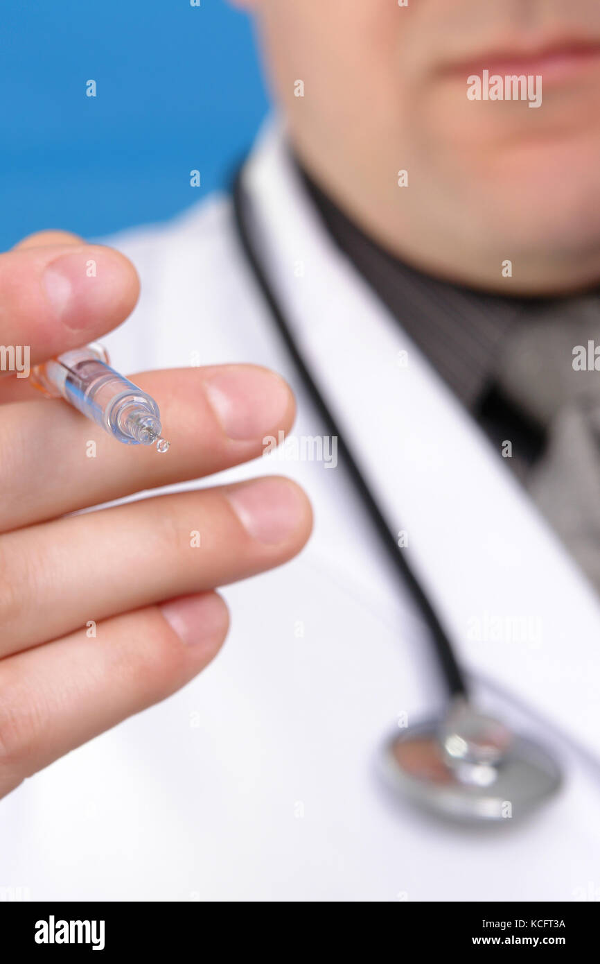 Nahaufnahme der Hand Arzt holding Spritze mit Kanüle über blauer Hintergrund Stockfoto