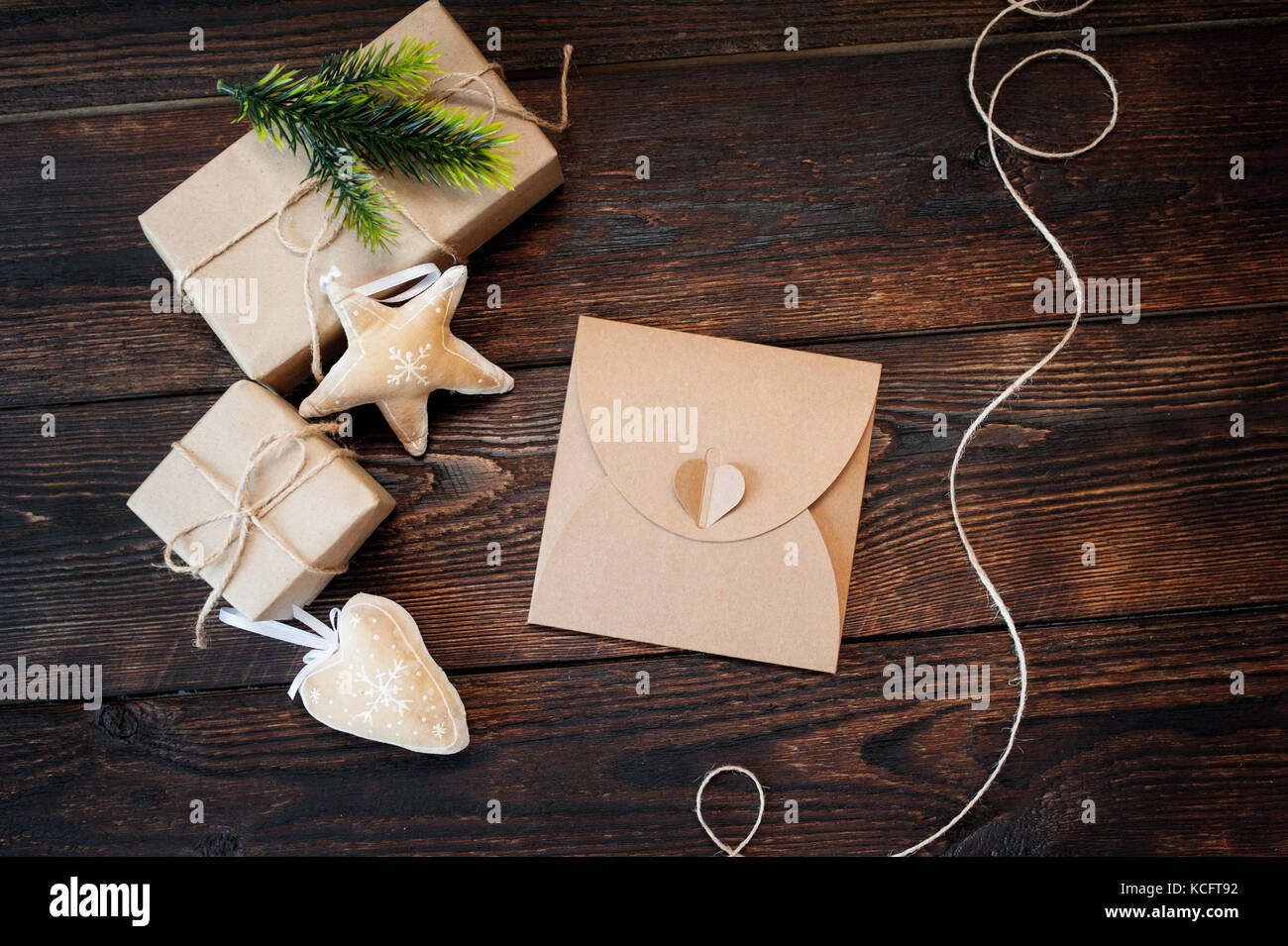 Weihnachten Zusammensetzung der Geschenk Kraftpapier Boxen, textile Spielwaren und Netzkabel Rahmen auf Holz- Hintergrund Stockfoto
