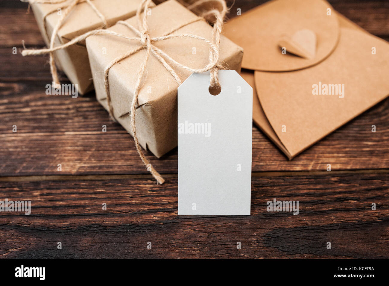 Mockup Kraftpapier Geschenkboxen mit Tag auf hölzernen Hintergrund Stockfoto