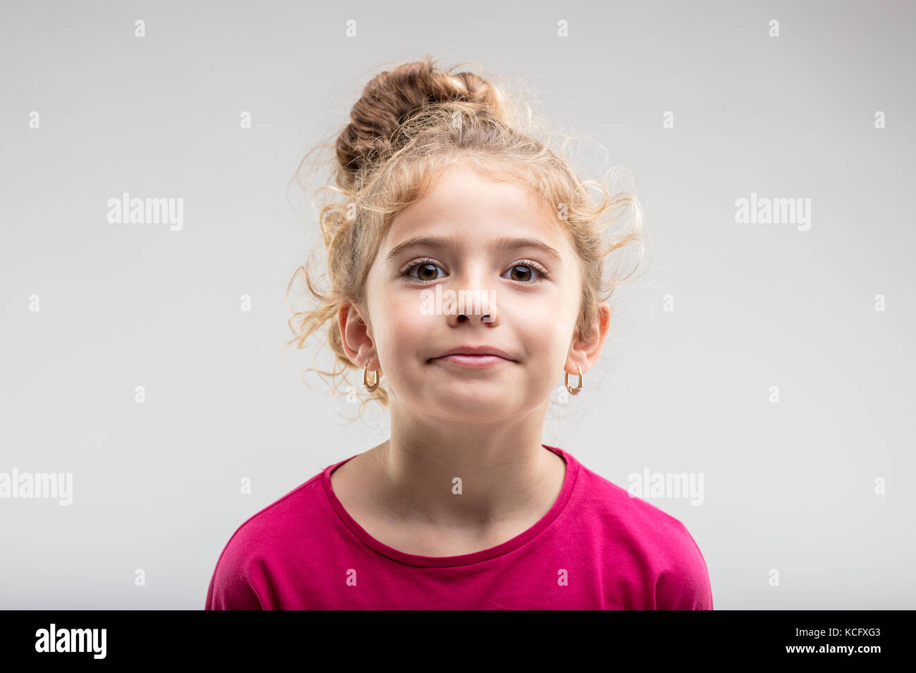 Porträt der jungen selbstbewussten jugendlichen Mädchen mit Blick auf die Kamera vor einfachen Hintergrund Stockfoto