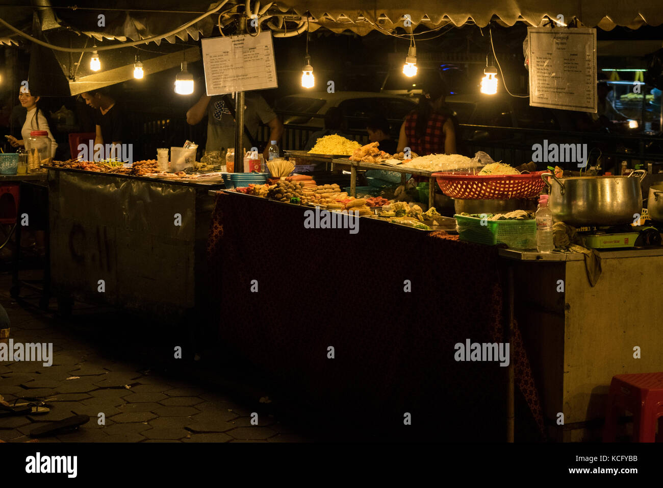 Ein asiatisches Essen Hersteller, Verkauf Straße essen im Phnom Penh Night Market, in Kambodscha. Das Essen ist meistens gebraten und billig, Experimentieren und serviert asiatische Küche. Stockfoto