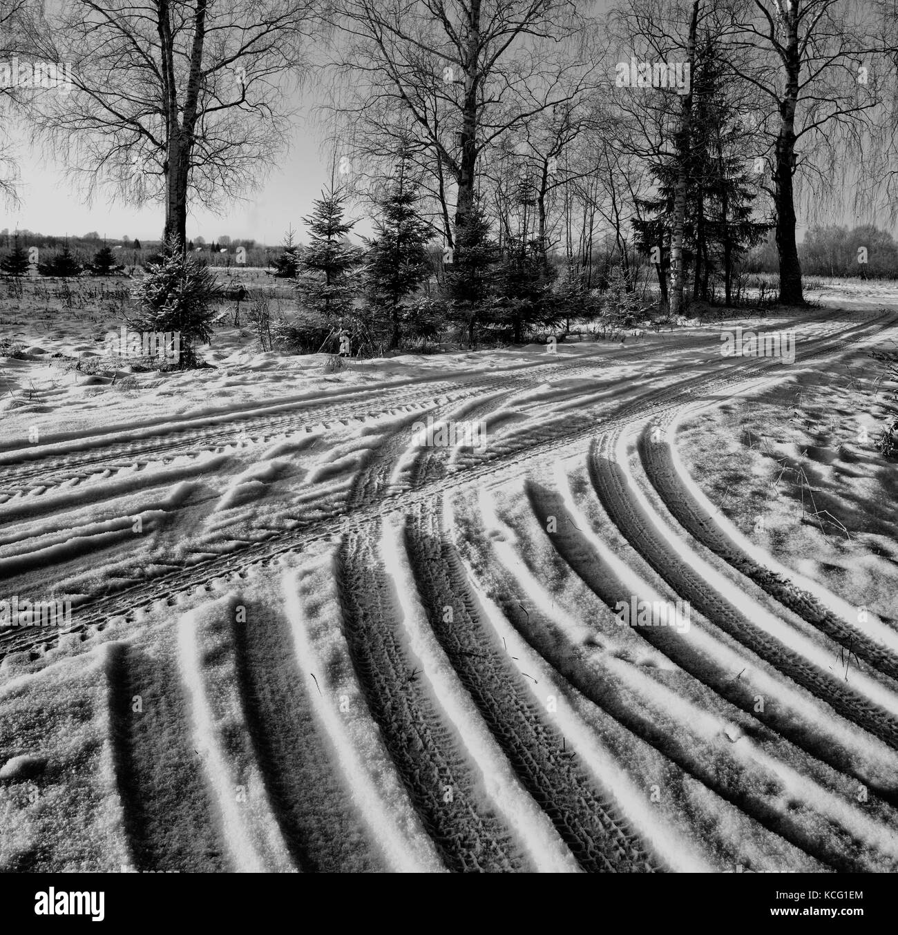 Winterdienst mit Spuren des Autoreifens. verschneite Straße nach dem letzten Schneefall. Landstraße. Fahrbahn kleine Größe. Radspuren auf der Straße im Winter Stockfoto