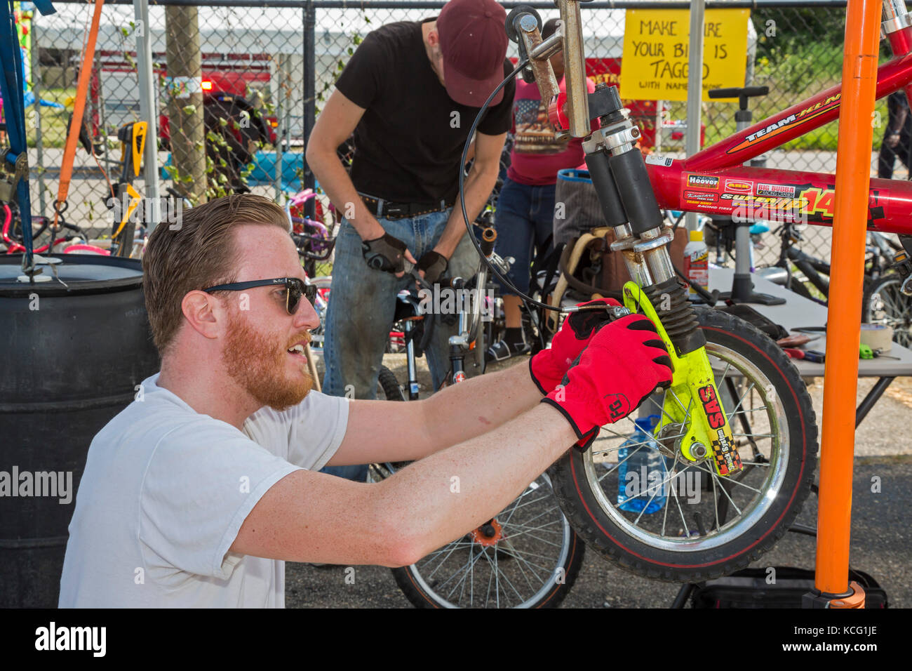 Detroit, Michigan - Männer arbeiten auf der Dream of Detroit Street Fair an Kinderfahrrädern. Stockfoto