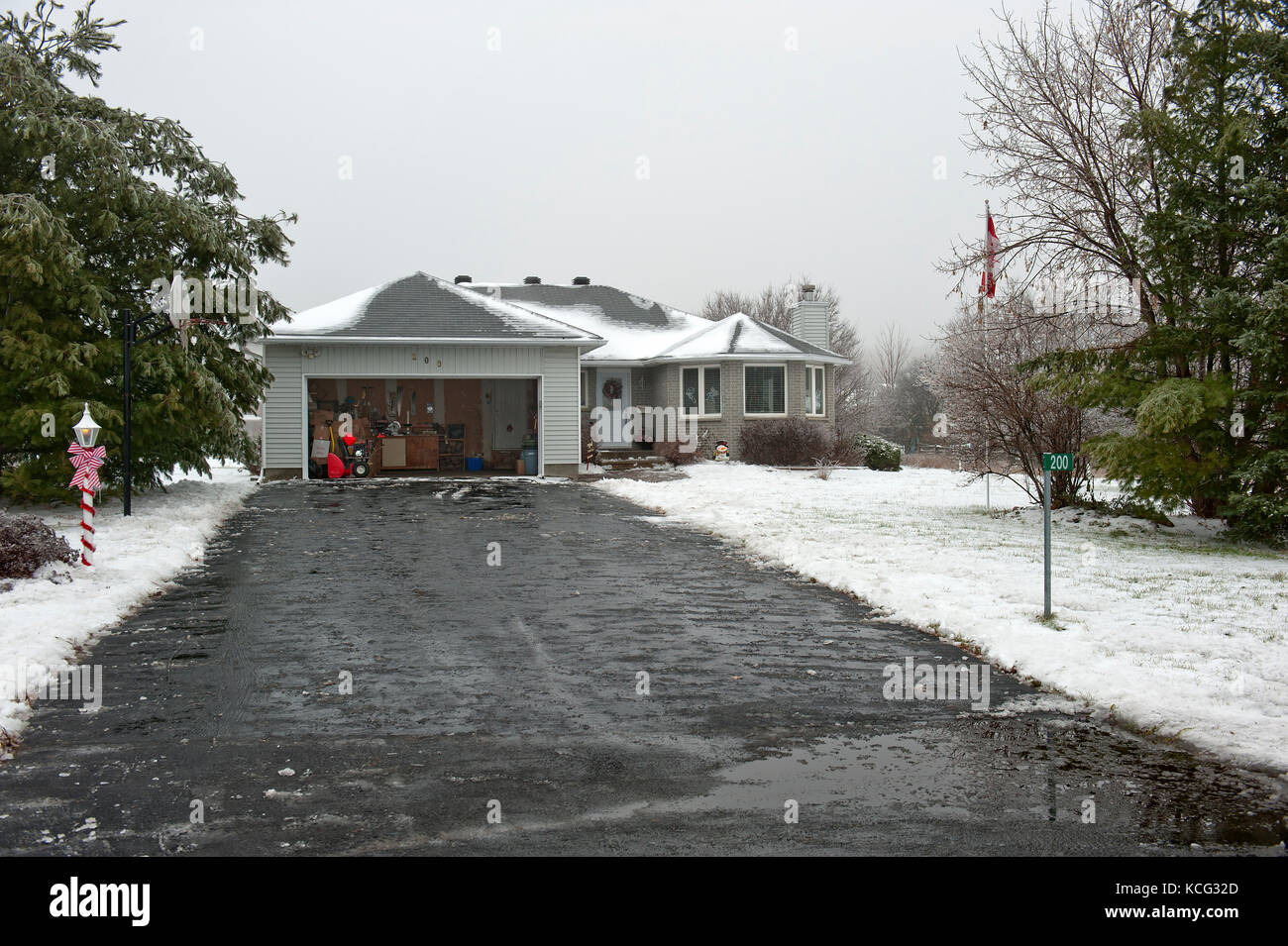 Nass schwarze Fahrstraße bei surban Family Bungalow im Winter Stockfoto