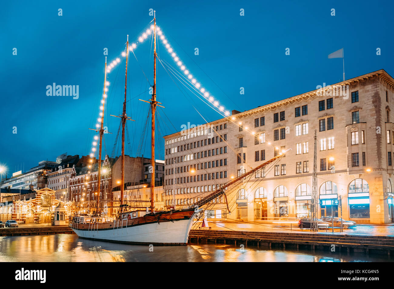 Helsinki, Finnland. Alte hölzerne Segelboot Schiff Schoner ist mit der Stadt pier, Steg vertäut. ungewöhnliche Cafe Restaurant im Stadtzentrum in Beleuchtung in Ev Stockfoto