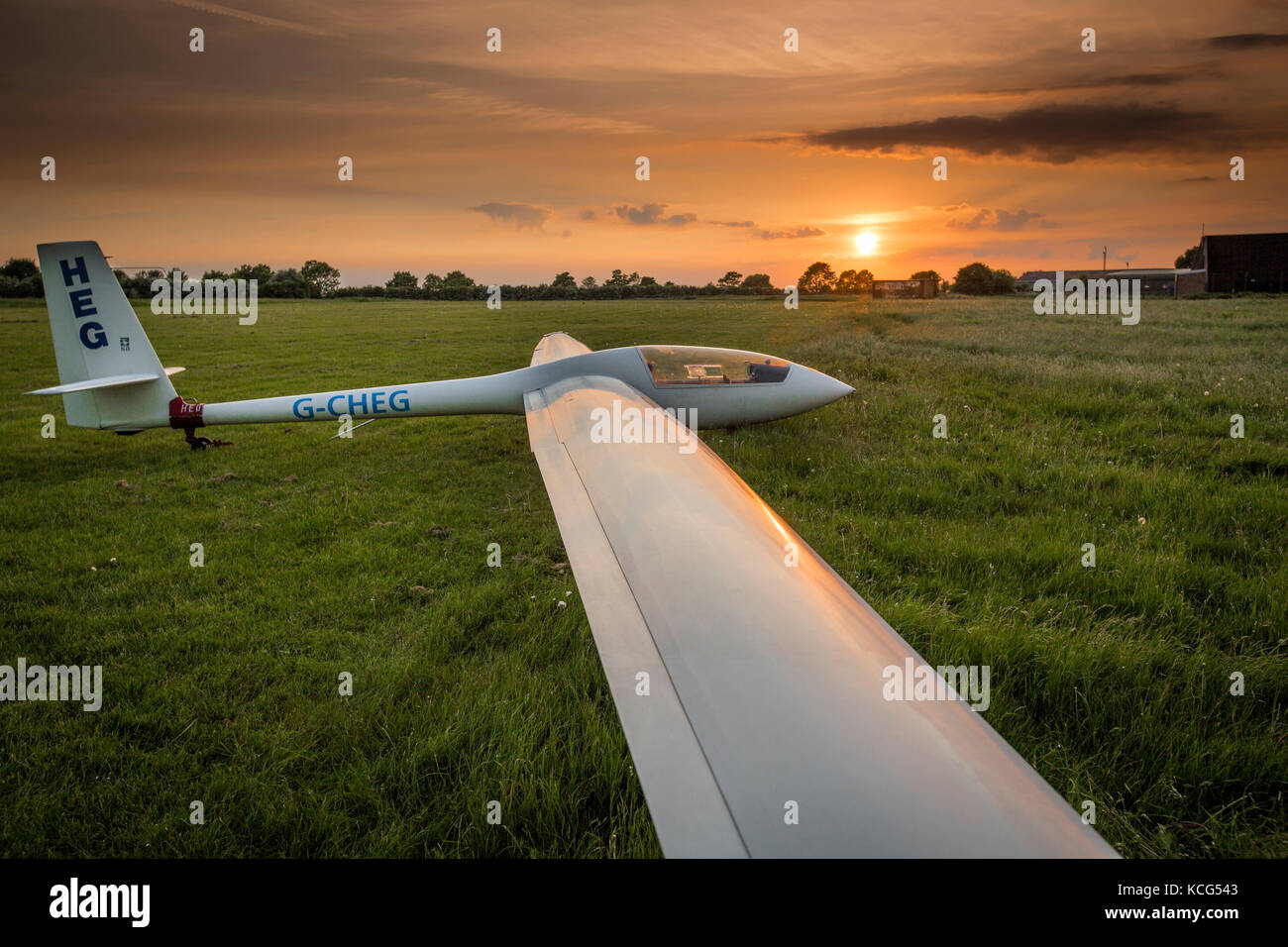 Blick auf ein Elan DG-500 Trainer einsitzigen Segelflugzeug mit der untergehenden Sonne an kirton in Lindsey Flugplatz, Lincolnshire, Großbritannien - 21 July 2014 Stockfoto