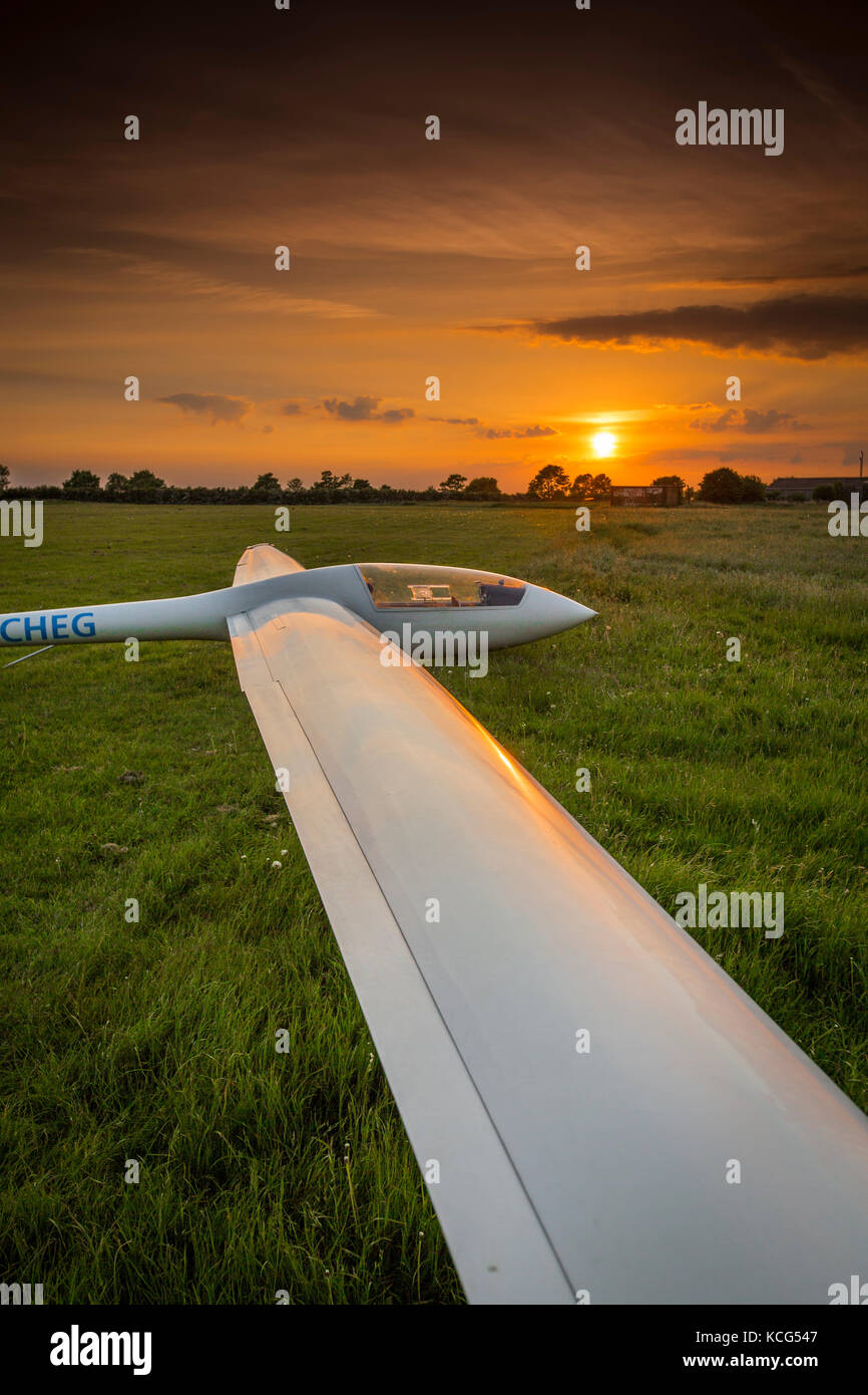 Blick auf ein Elan DG-500 Trainer, Registrierung g-cheg, einsitzigen Segelflugzeug mit der untergehenden Sonne an kirton in Lindsey Flugplatz, Lincolnshire, Großbritannien Stockfoto