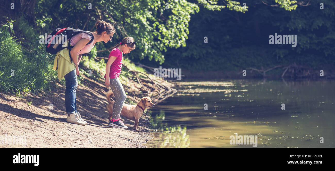 Mutter und Tochter mit Hund Ruhe am See Stockfoto