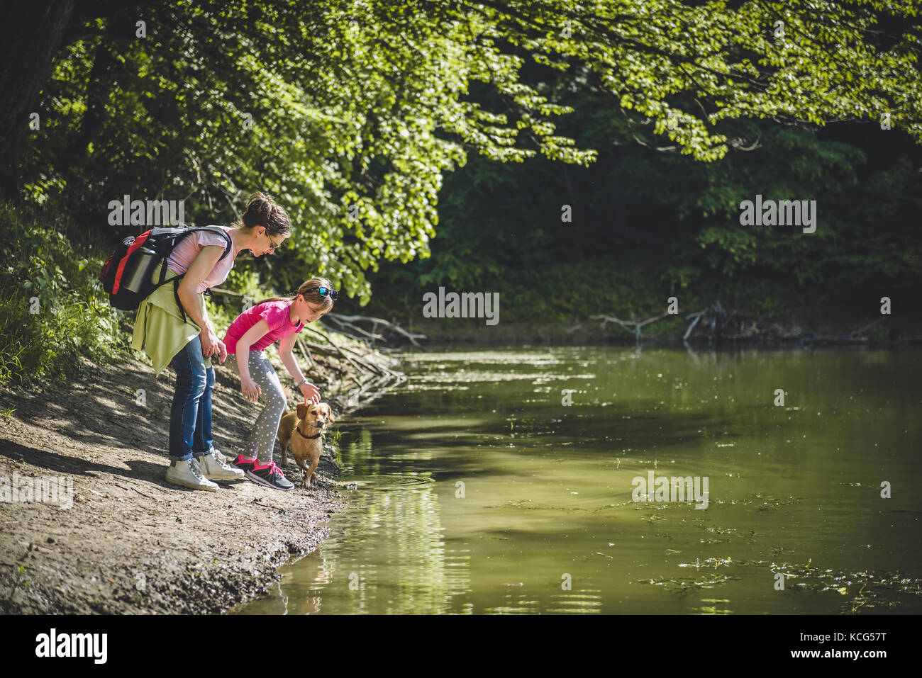 Mutter und Tochter mit Hund Ruhe am See Stockfoto