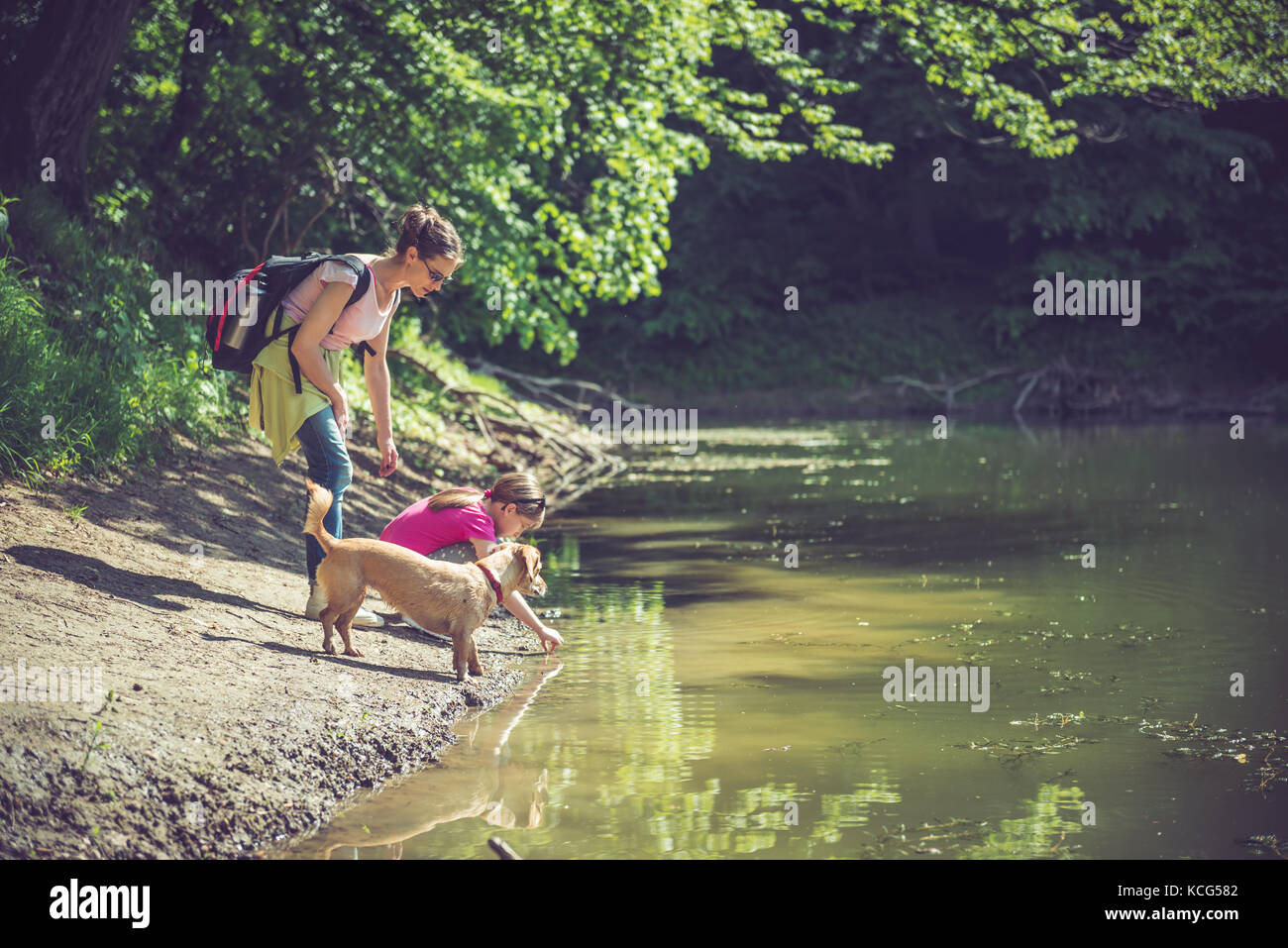 Mutter und Tochter mit Hund Ruhe am See Stockfoto