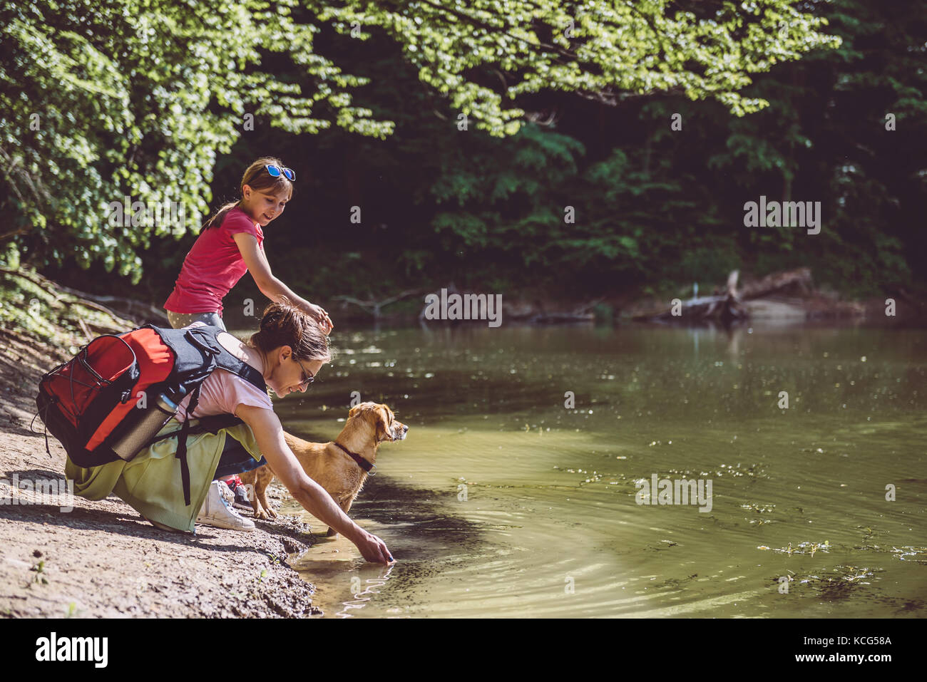 Mutter und Tochter mit Hund Ruhe am See Stockfoto