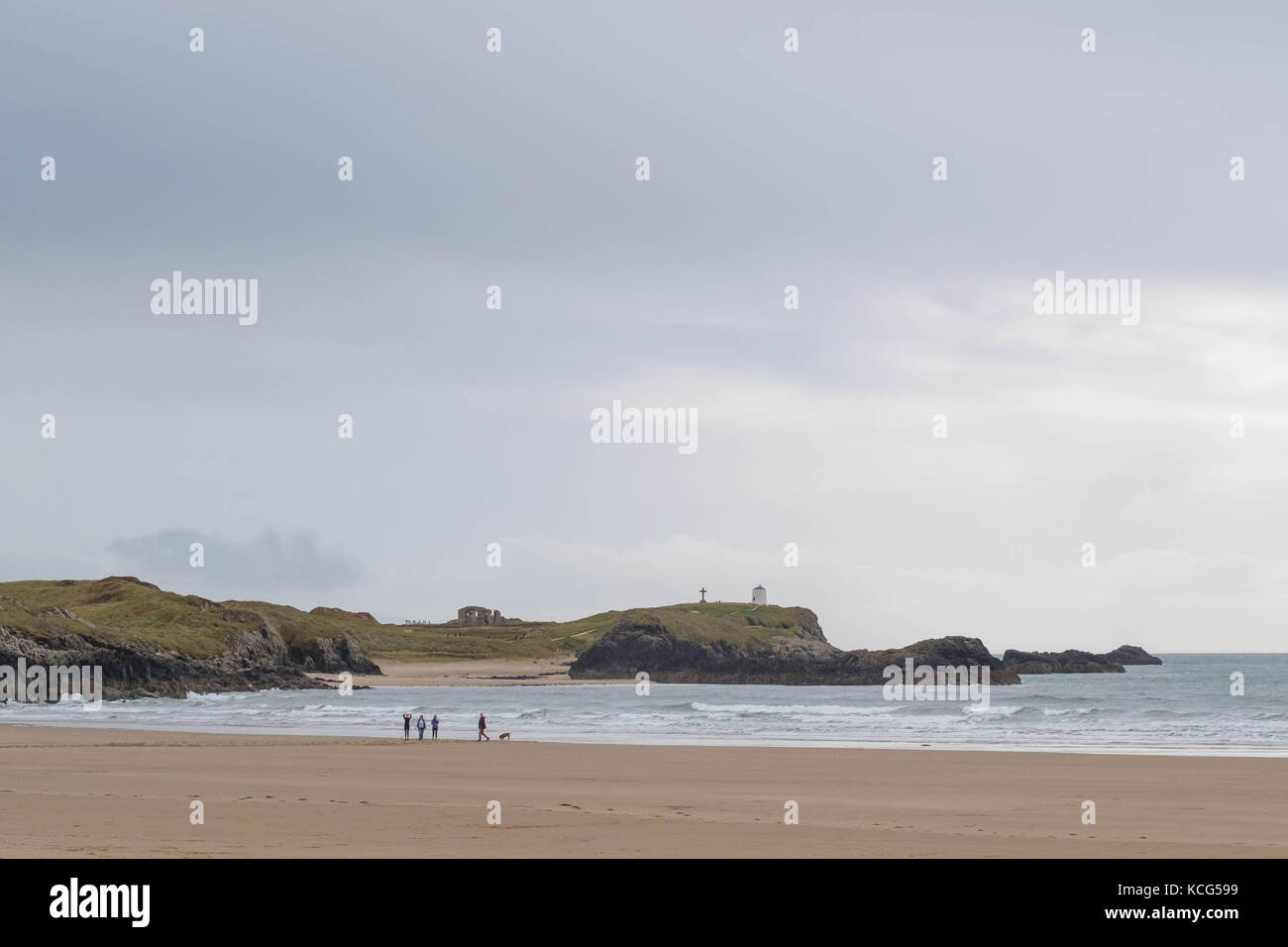Familie und Hund Wandern am Rand des Meeres auf rhosneigr Strand, Insel Anglesey, North Wales, UK Stockfoto