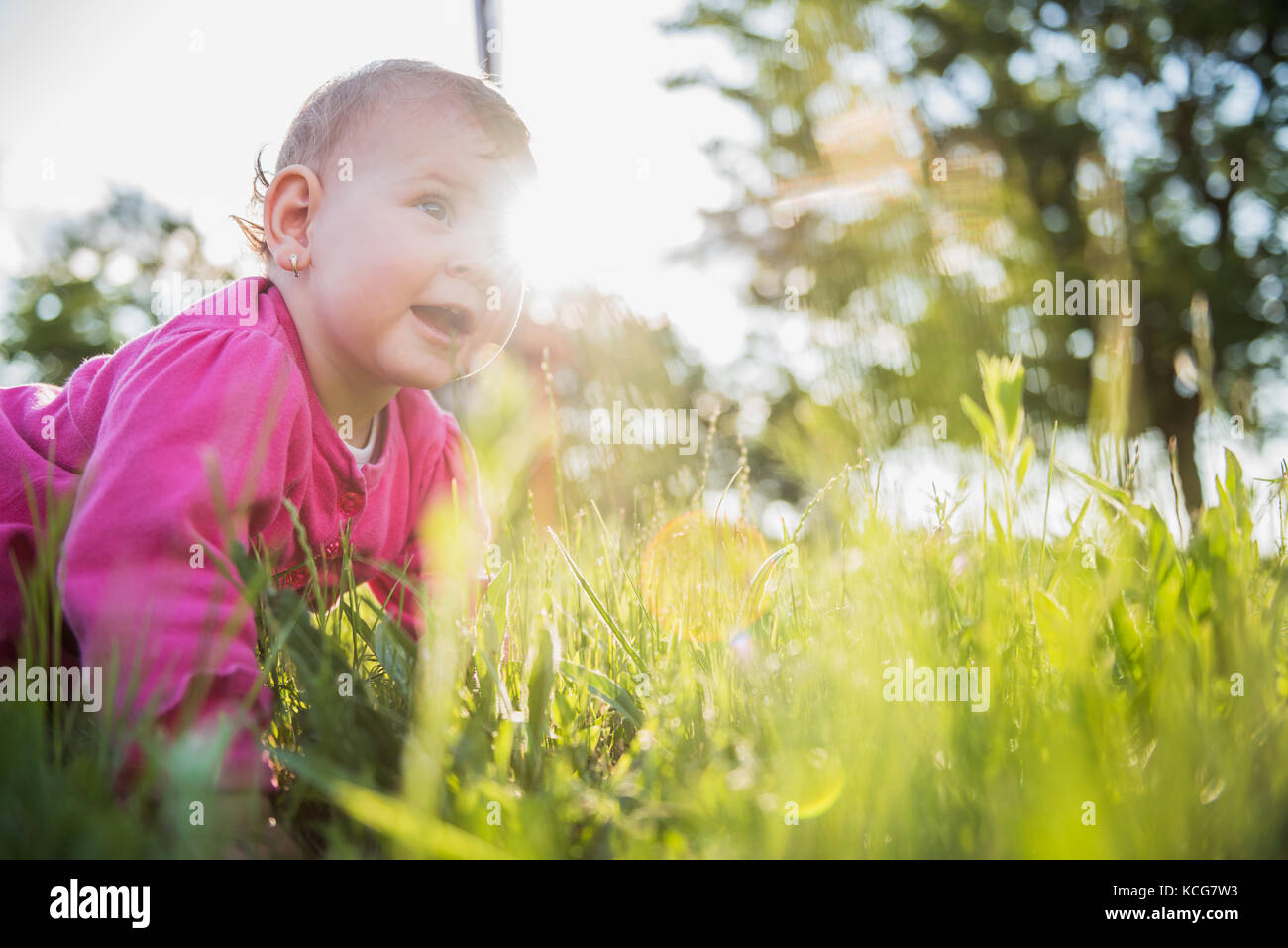 Happy Baby rose Pullover tragen, spielen auf dem Rasen Stockfoto