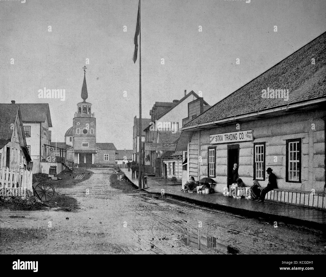 Vereinigte Staaten von Amerika, Straßenszene in der Mitte der Stadt Sitka an einem regnerischen Tag, Menschen vor einem Geschäft und die Kirche am Ende der Straße, Alaska sitzen, digital verbesserte Reproduktion einer historischen Foto aus dem (geschätzten) Jahr 1899 Stockfoto