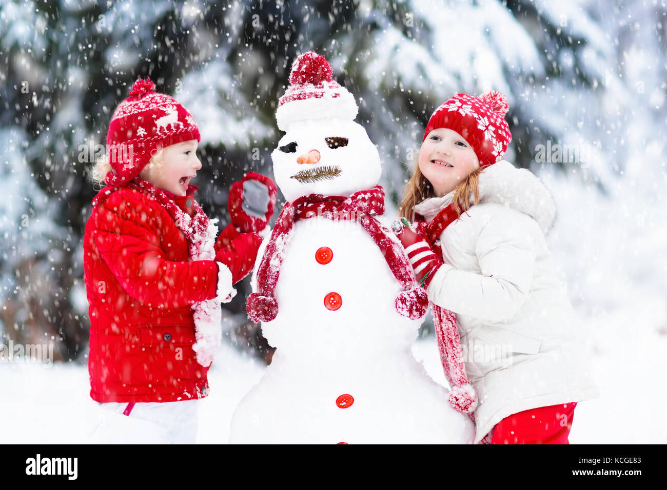 Urlaub Kinder Weihnachten 2022 Kinder bauen Schneemann. Kinder bauen Schneemann spielen im Freien an