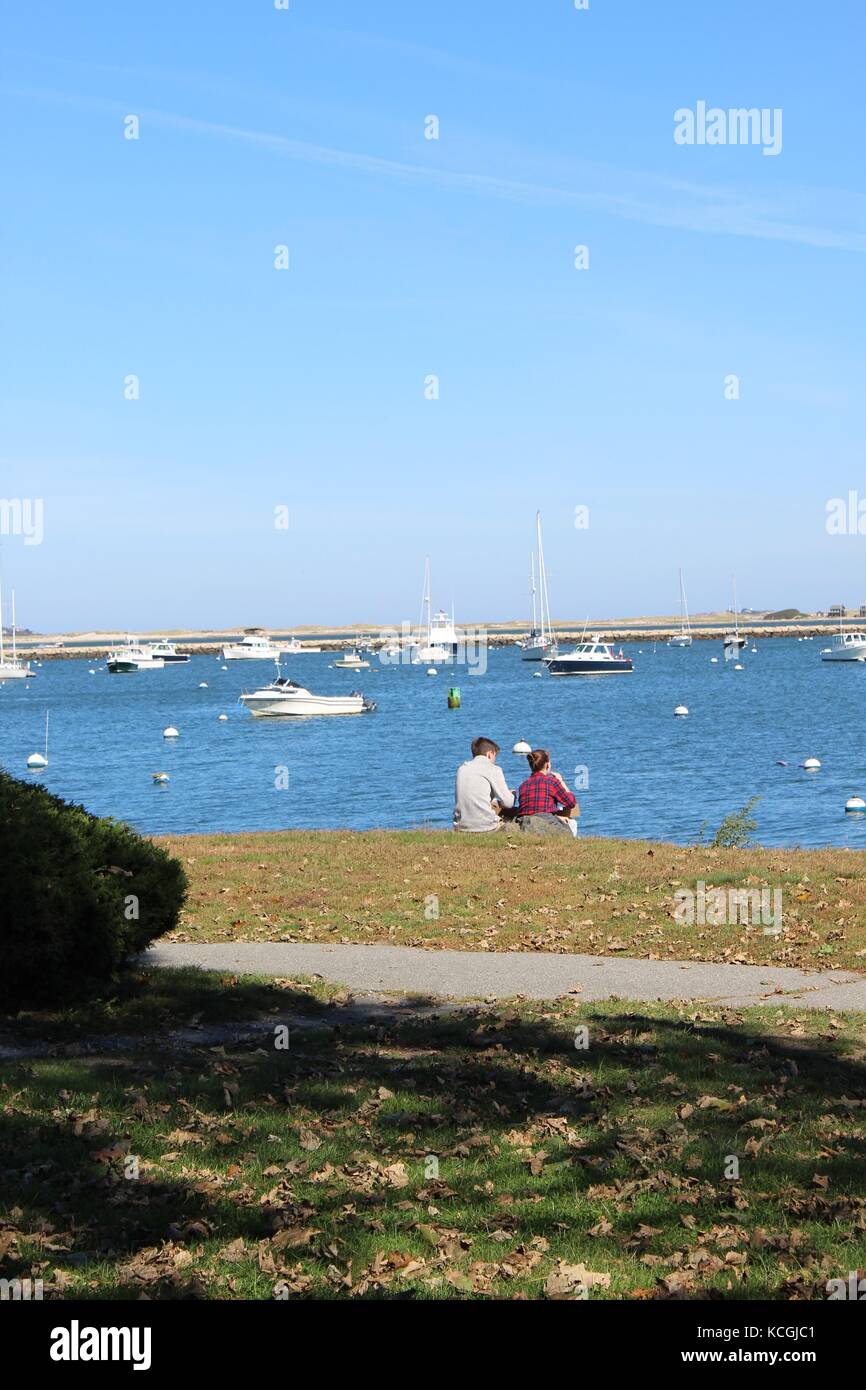 Paar sitzt durch das Wasser auf den Atlantischen Ozean bei Boote und Schiffe in New England in der Nähe von Plymouth Rock suchen Stockfoto