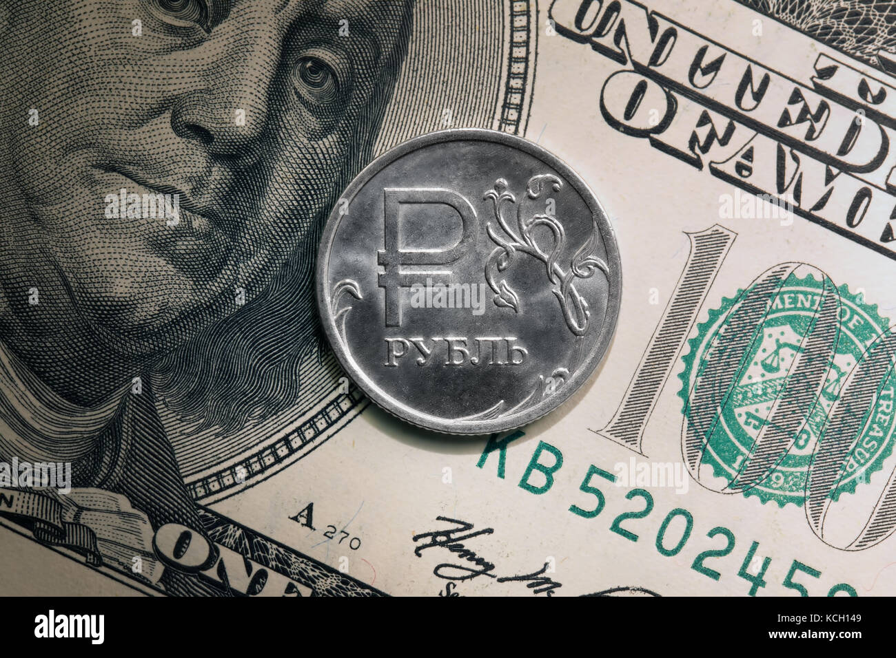 Eine Nahaufnahme des Rubels Münze und 100 US-Dollar Banknote mit einem Portrait von Benjamin Franklin Stockfoto