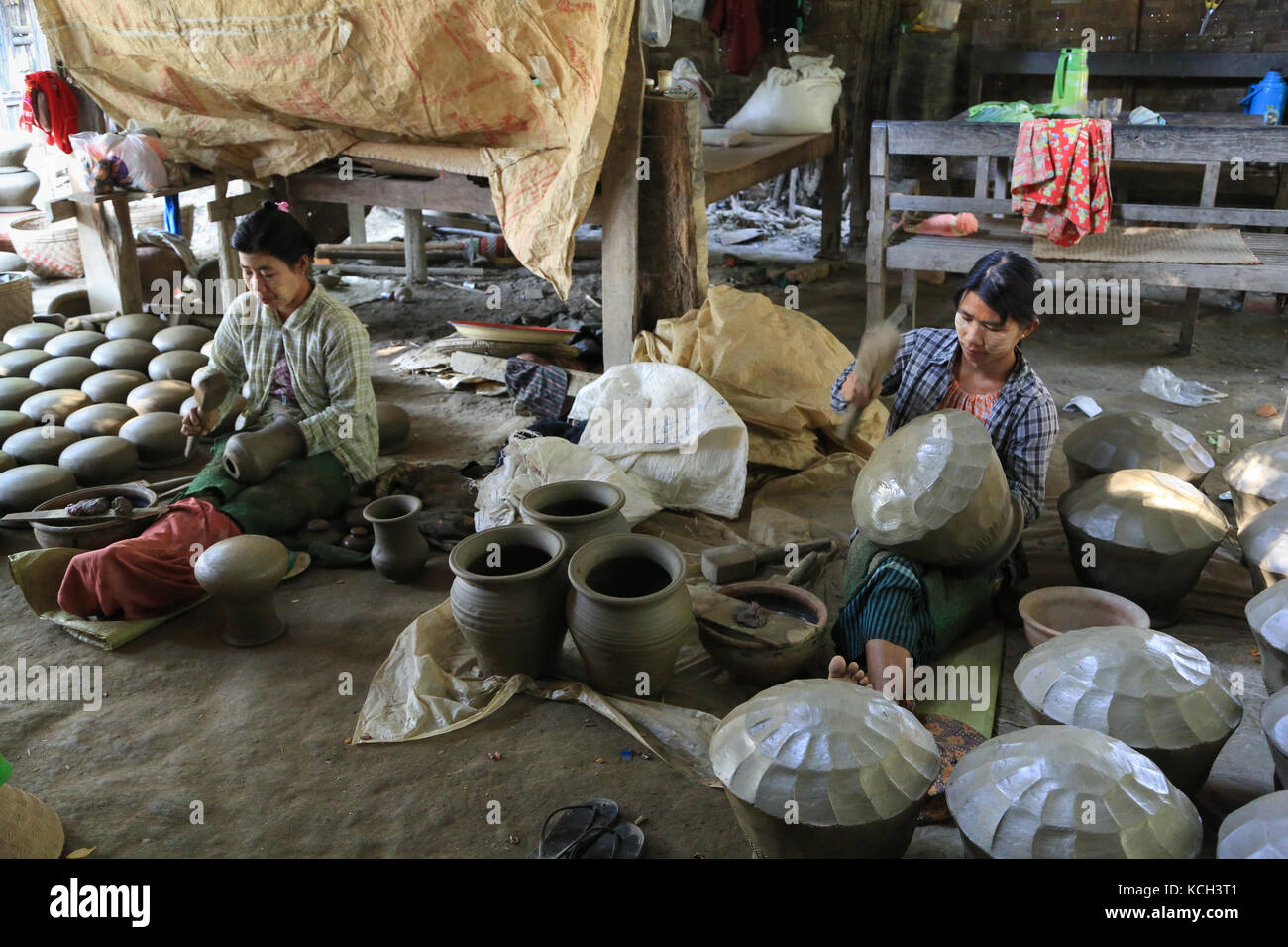 Zwei Frauen sind mit Holz Paddel zu bilden Töpfe in Yandabo Dorf auf dem Irrawaddy Fluss in Myanmar (Burma). Stockfoto