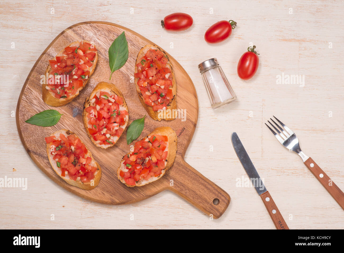 Leckere italienische Bruschetta mit Brot mit Tomaten und Kräutern auf Holzbrett gekrönt Stockfoto
