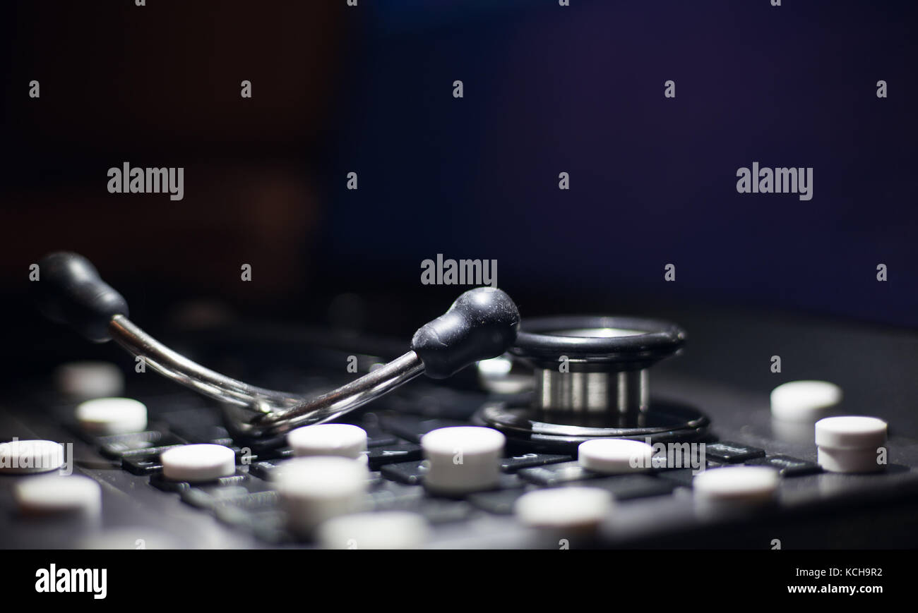 Laptop Tastatur mit Medizin Tablette Medikamente und medizinische Stethoskop Stockfoto