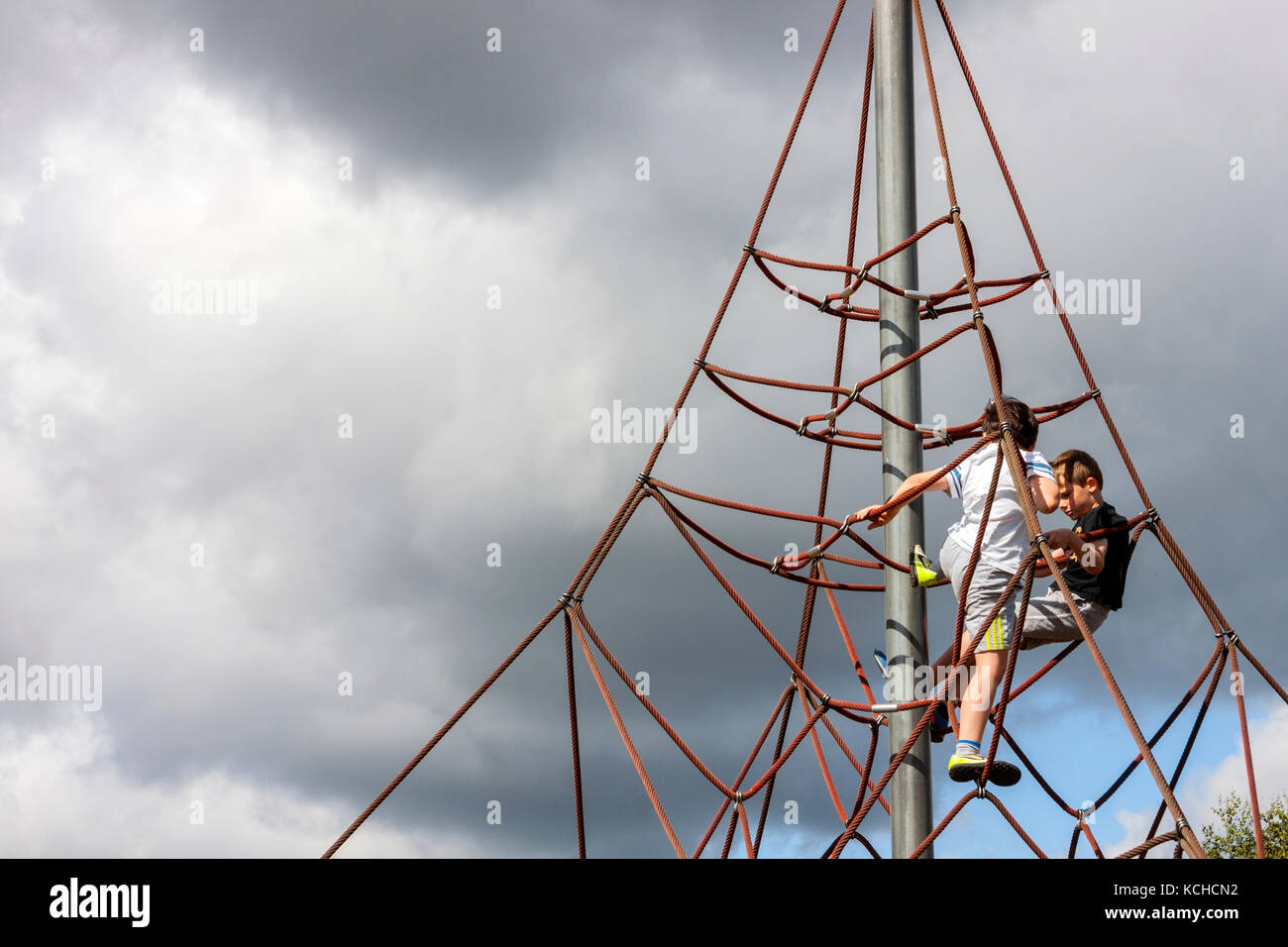 Die jungen Klettern Apparate in Spielplatz Stockfoto