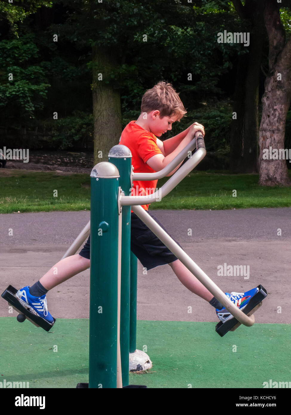 Junge, 8 Jahre, mit Fitnessgeräten im öffentlichen Park Stockfoto