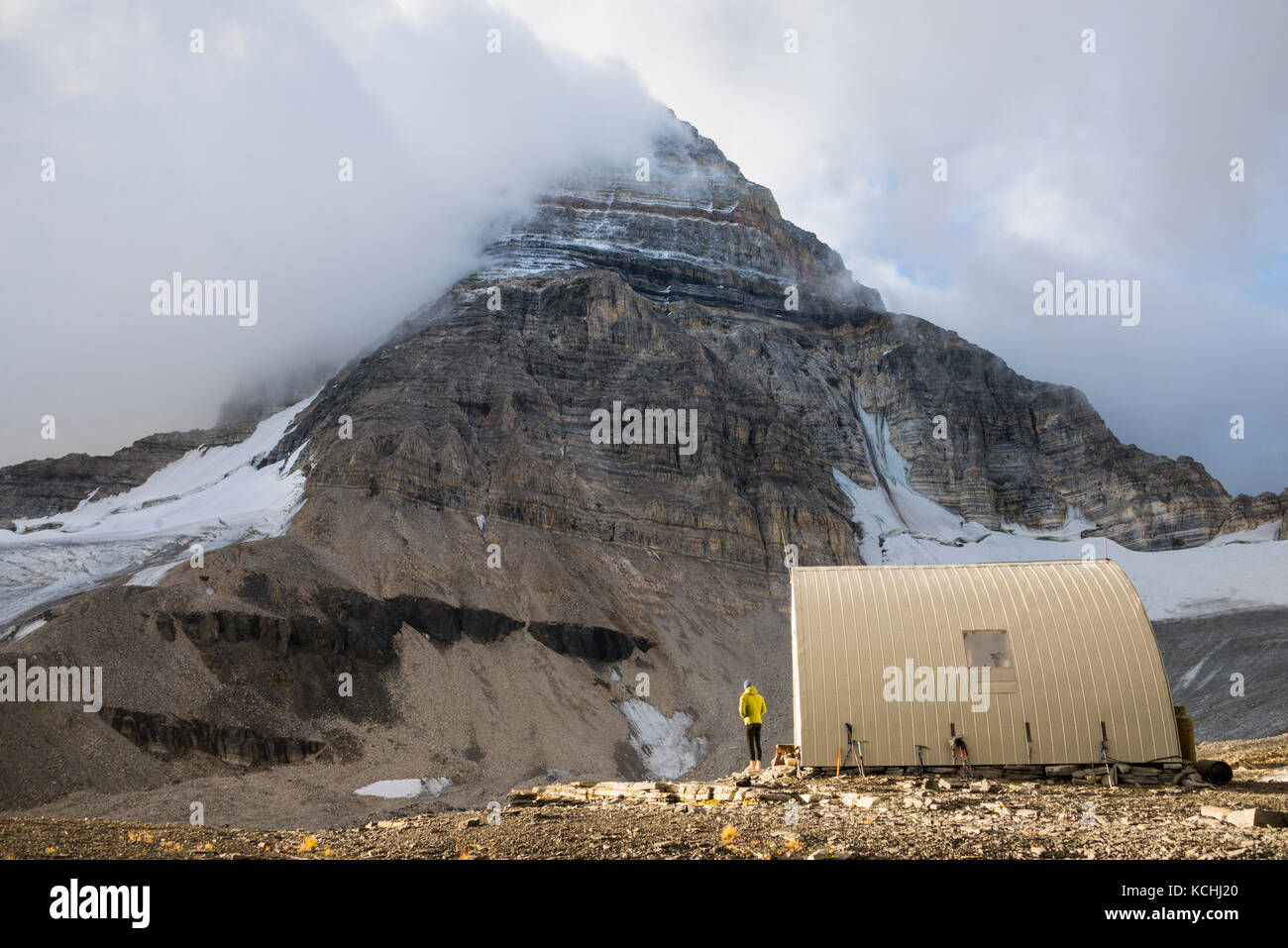 Ein Bergsteiger Geltungsbereiche der Gipfel, während an der R.C. Hind Hütte unter Mt. Assiniboine Stockfoto