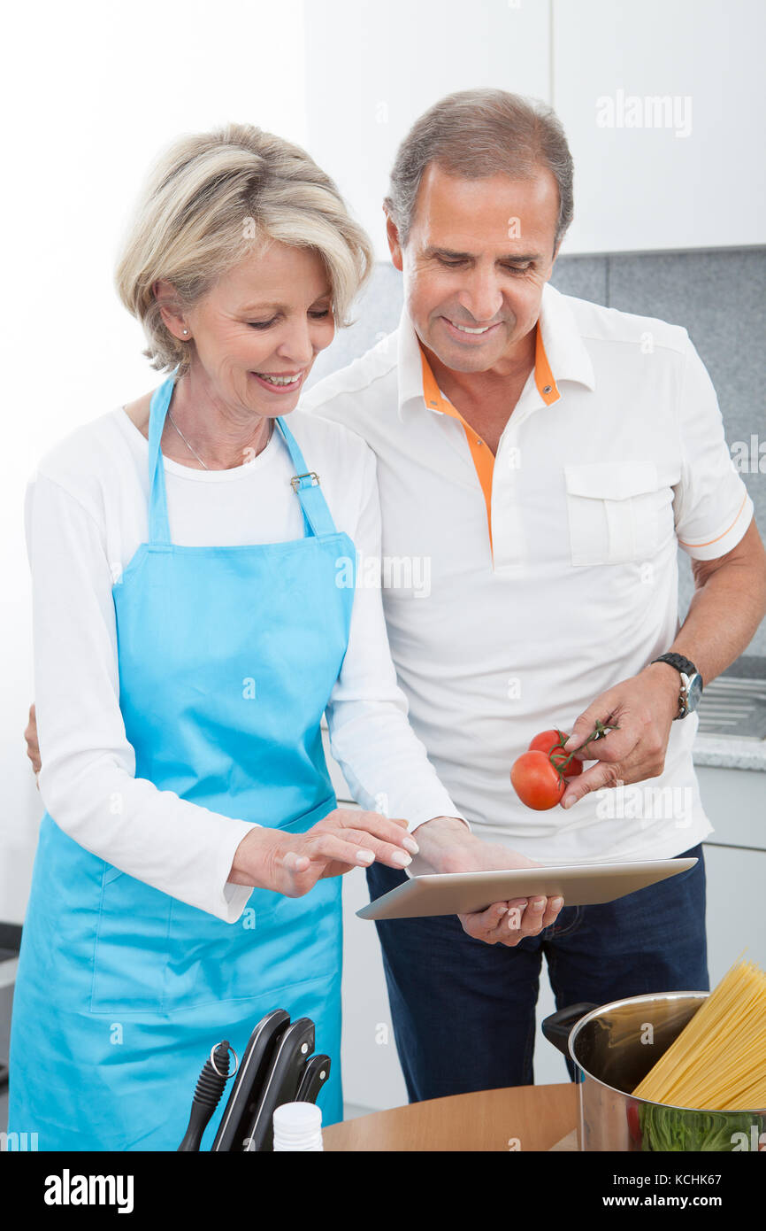 Reifer Mann und Frau Schneiden von Gemüse in der Küche Stockfoto