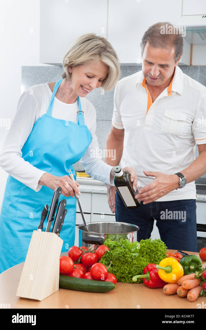 Mann Schaut Auf Die Frau, Die In Der Küche Lebensmittel Zubereitete Stockfoto