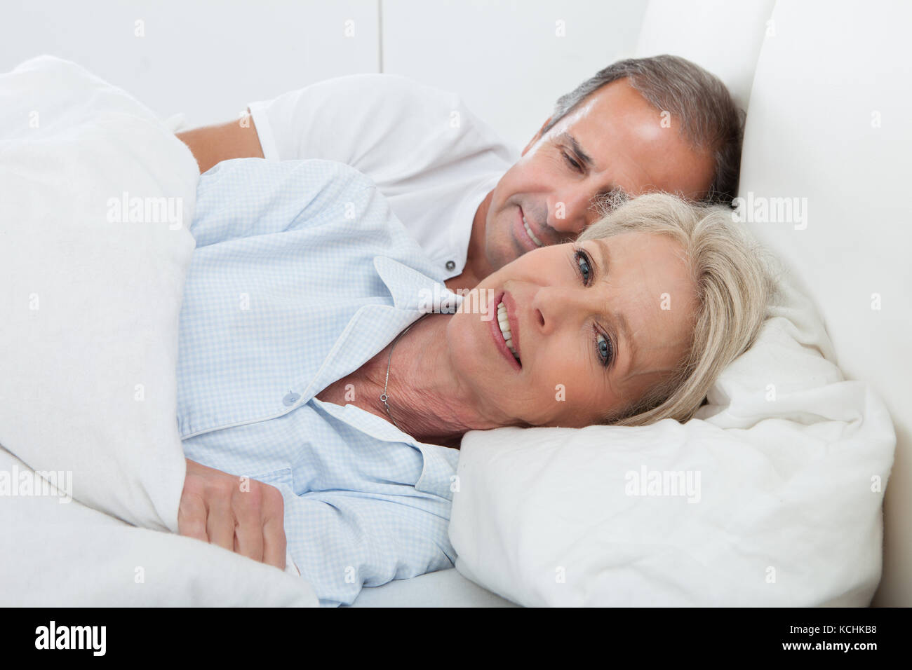 Portrait Of Happy Senior Couple zusammen im Bett Stockfoto