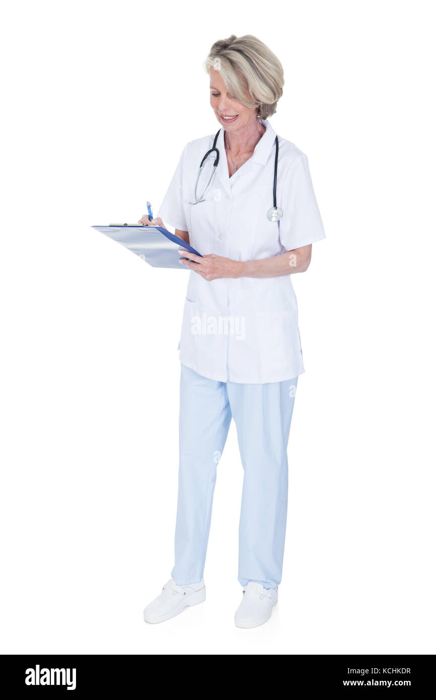 Reife Frau Doktor-Schrift auf Zwischenablage Over White Background Stockfoto Reife Frau Doktor-Schrift auf Zwischenablage Over White Background Stockfoto