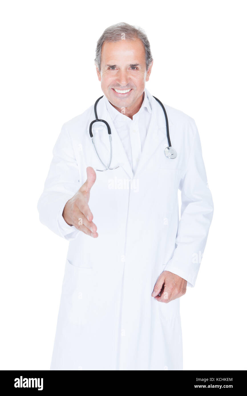 Porträt von männlichen Arzt Angebot Handshake Over White Background Stockfoto