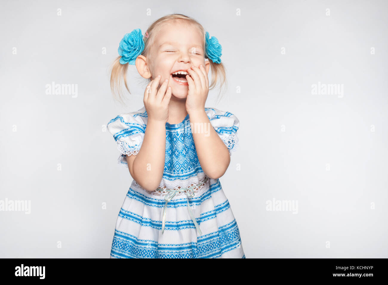 Lachende süsse kleine Mädchen auf weißem Hintergrund Stockfoto