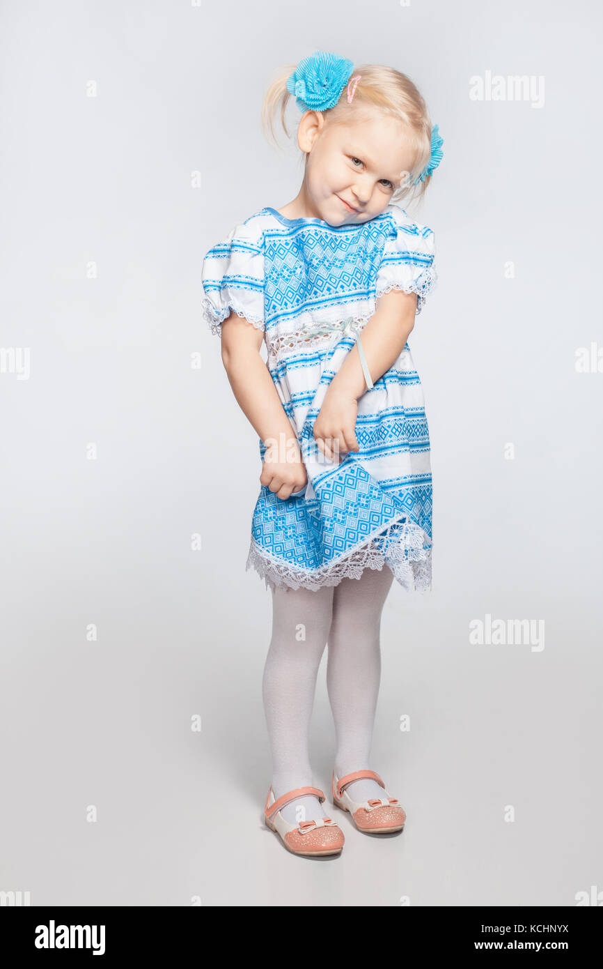 Süße kleine Blonde Mädchen auf einem weißen Hintergrund schüchtern Stockfoto
