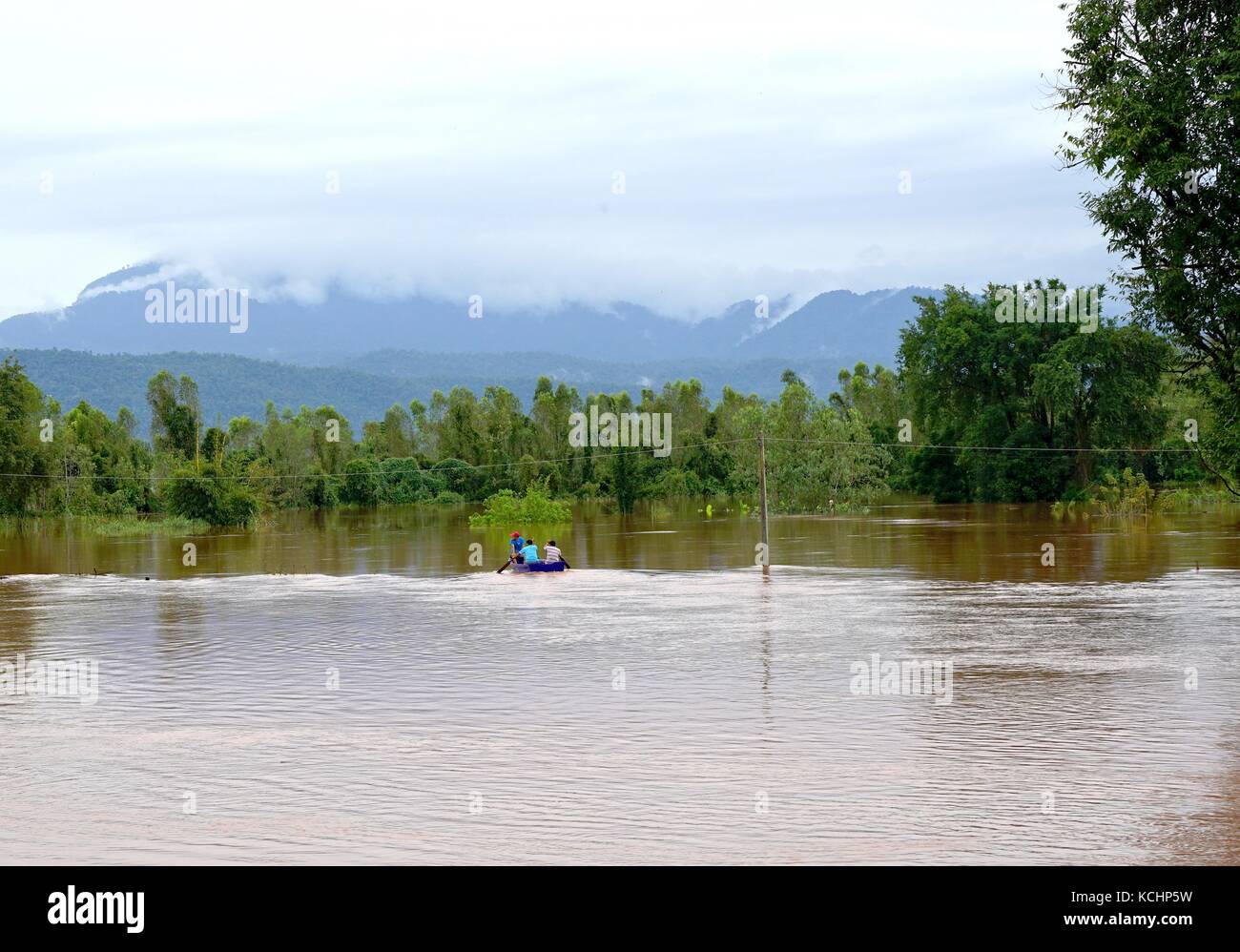 Phitsanulok, Thailand - September 16,2017: Flash Flood von Red trübes Wasser fließt vom Berg aufgrund der sintflutartigen Regenfälle mit Menschen paddeln Boa Stockfoto