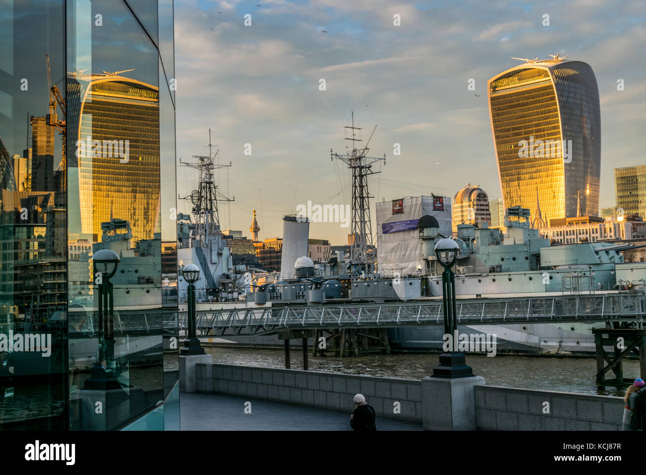 Golden Sunset Reflexion walkie talkie Gebäude im modernen verglasten Gebäude an der South Bank in London mit der HMS Belfast wiederholt Stockfoto