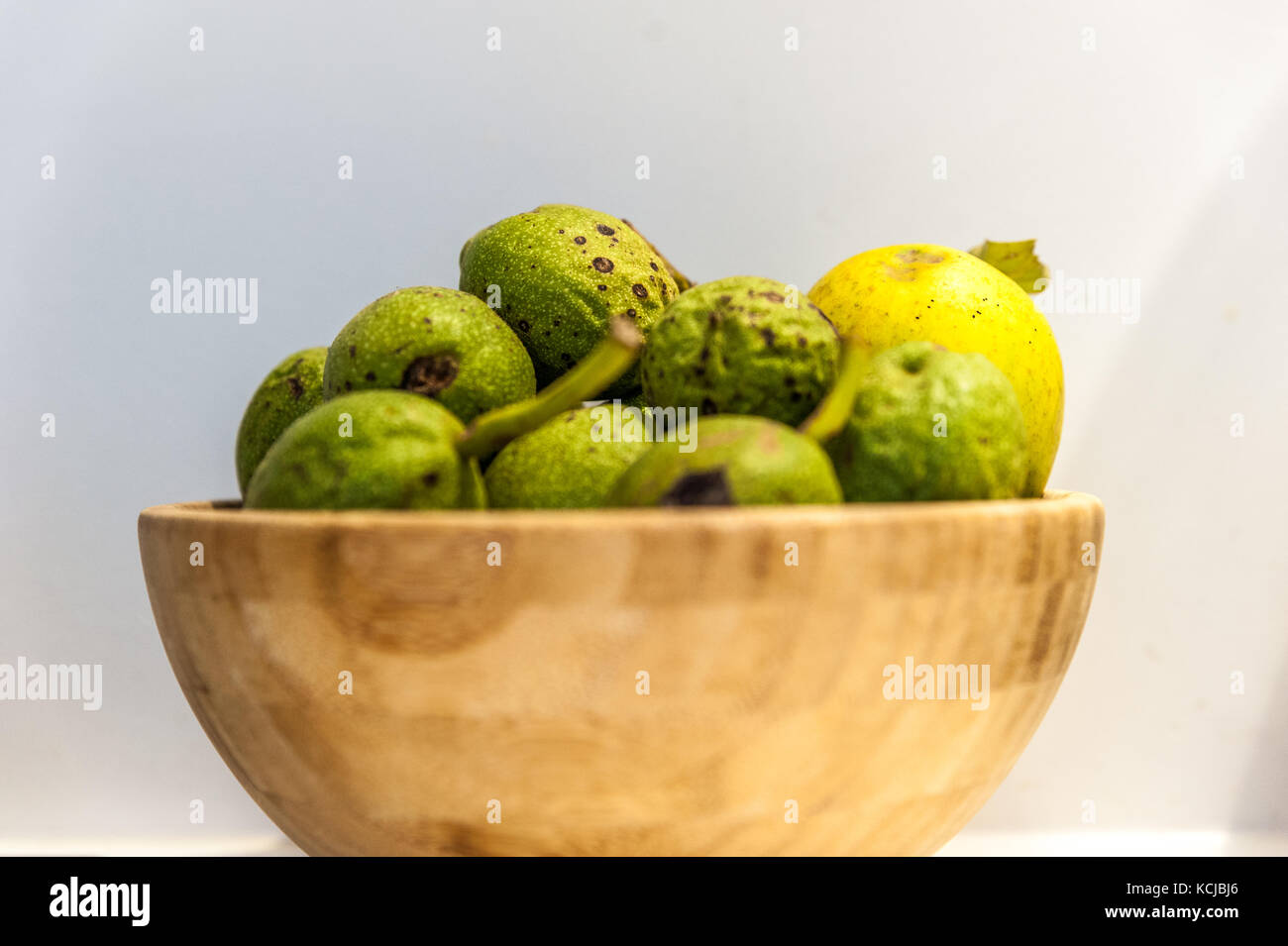 Grüne, frische Walnüsse in eine hölzerne Schüssel Stockfoto