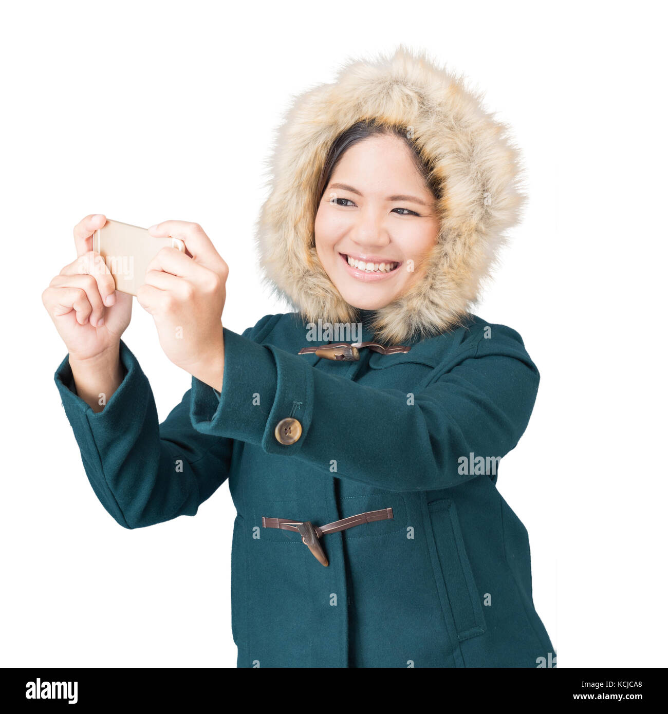 Asiatische Frau mit grünen Mantel mit Fell Hut isoliert auf weiss Stockfoto