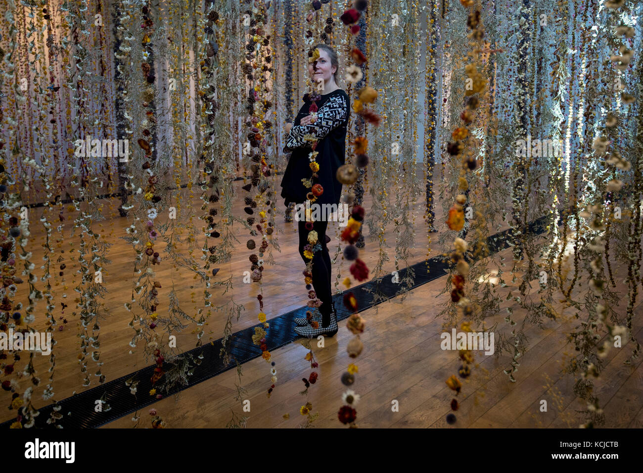 Die Künstlerin Rebecca Louise Law mit ihrer neuen Hängeinstallation "Life in Death" mit 375,000 Blumen in der Shirley Sherwood Gallery of Botanical Art, Teil von Artful Autumn at Kew Gardens im Südwesten Londons. Stockfoto