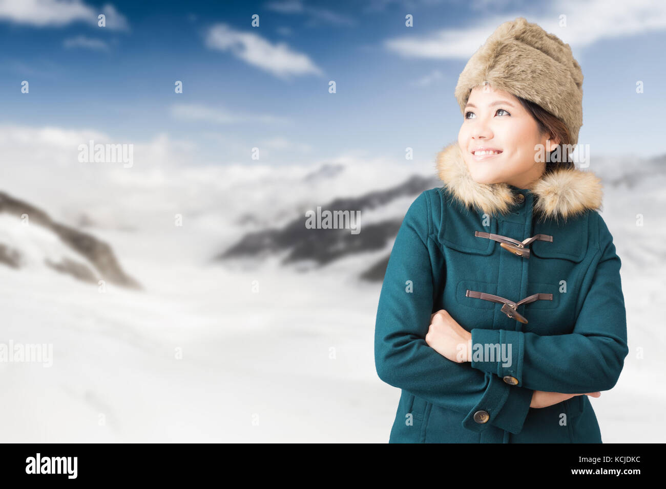 Asiatische Touristen Tragen von grünen Mantel mit Snow Mountain Hintergrund Stockfoto