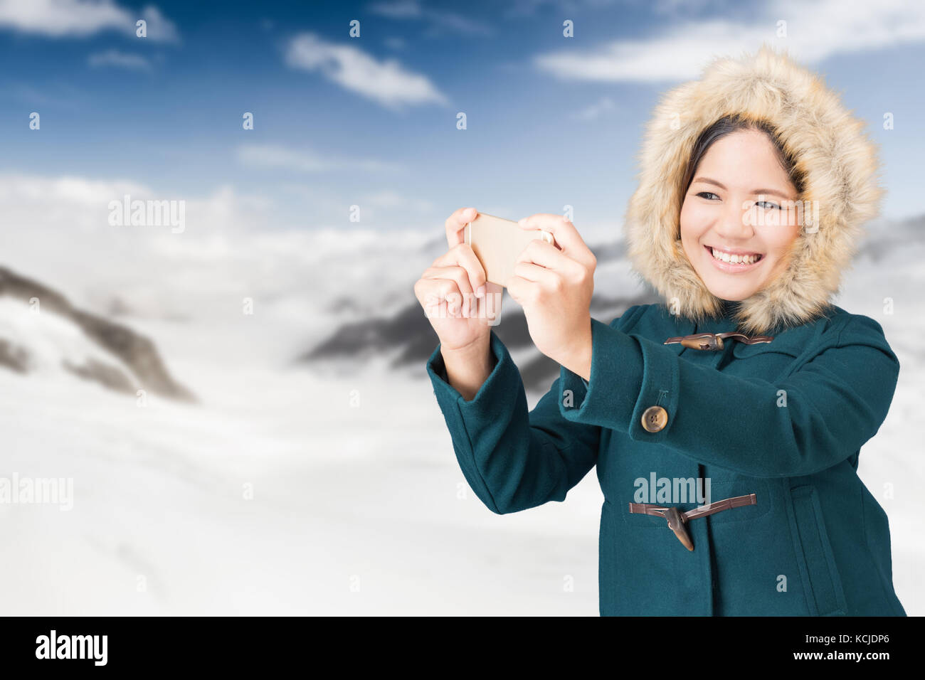 Asiatische Touristen Tragen von grünen Mantel mit Snow Mountain Hintergrund Stockfoto