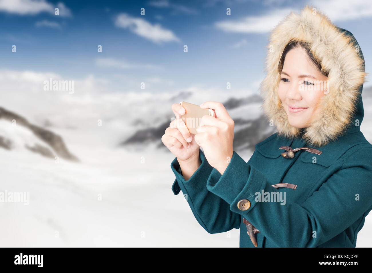 Asiatische Touristen Tragen von grünen Mantel mit Snow Mountain Hintergrund Stockfoto