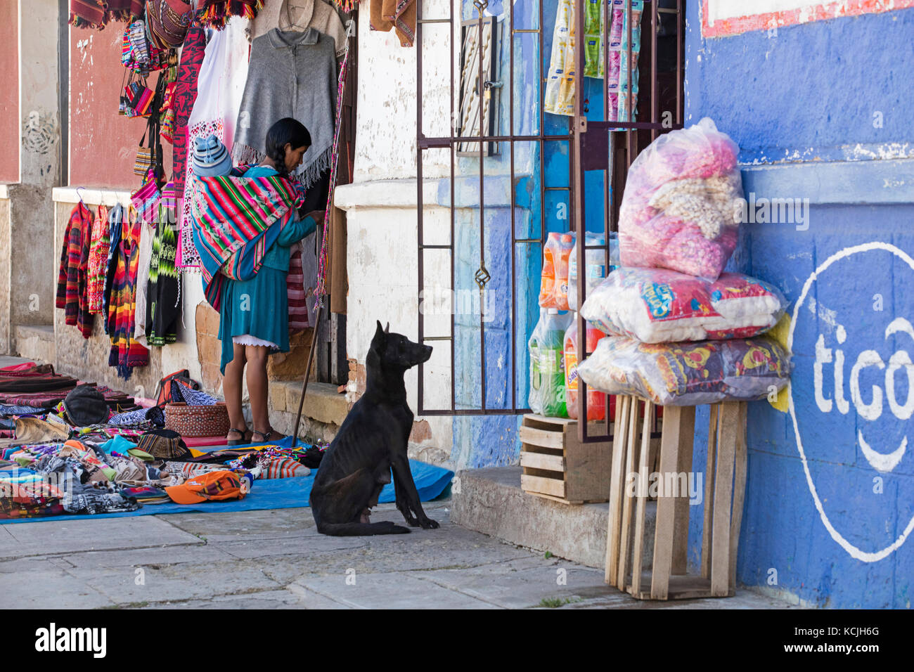 Bolivianische Frau, die beim Einkaufen in der Stadt Tarabuco, Chuquisaca, Provinz Yamparáez, Bolivien, ein Kind auf dem Rücken trägt Stockfoto
